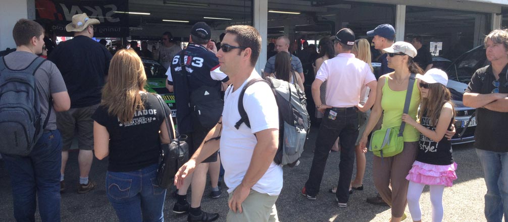 Spectators gather around the Pit Garage minutes before the cars go out to compete